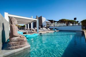 a resort swimming pool with a statue in the water at Le Spinaker in Le Grau-du-Roi