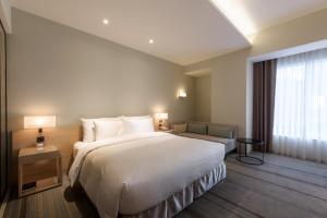 Postel nebo postele na pokoji v ubytování Hotel COZZI Zhongshan Kaohsiung