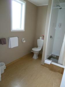a bathroom with a toilet and a window at Monarch Motel in Invercargill +30 photos