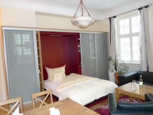 a bedroom with a bed and a couch and a table at Villa Andante Apartmenthotel in Kassel