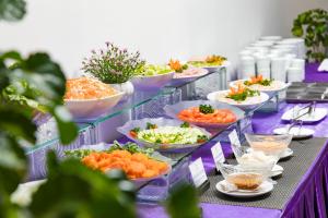 Een buffet met schalen vol eten op een paarse tafel. bij TTC Hotel Phan Thiet in Phan Thiet +44 foto's
