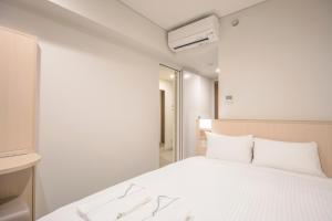 a white bedroom with a bed and a tv at Sotetsu Fresa Inn Kyoto-Hachijoguchi in Kyoto