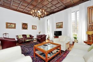 Prestigious Apartment Via Veneto في روما: غرفة معيشة بأثاث أبيض وثريا
