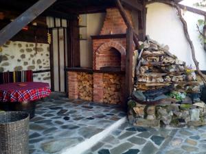 um forno de tijolos com uma pilha de lenha em Deny Holiday home em Dobrinishte