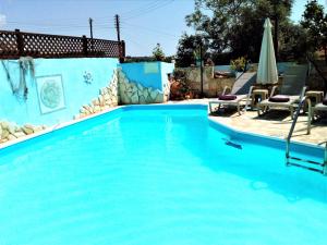 a swimming pool with blue water in a yard at Rose Garden Villa Peristerona in Peristerona