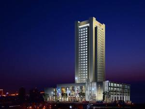 een hoog gebouw met veel ramen 's nachts bij Hui Fu Jinling Hotel in Gaoyou