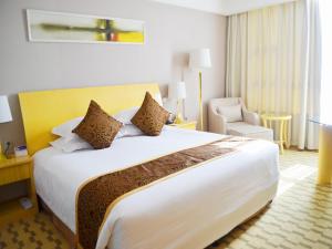 GaoyouにあるHui Fu Jinling Hotelの大きなベッドと椅子が備わるホテルルームです。