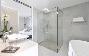 a bathroom with a glass shower and a sink at Le Spinaker in Le Grau-du-Roi