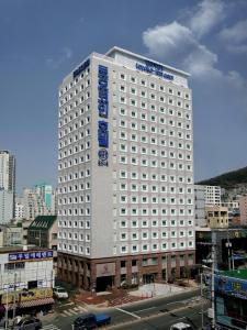 a large white building with a blue sign on it at Toyoko Inn Busan Seomyeon in Busan