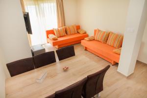 - un salon avec deux canapés orange et une table dans l'établissement Apartments Villa Matea, à Žaborić