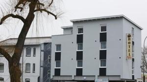 a white building with a hotel sign on it at Hotel Schillerquartier in Kassel