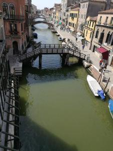 un puente sobre un canal con un barco en el agua en Corte Loredana, en Venecia