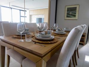 a wooden table with chairs and a dining room at Blouberg Luxury Beachfront Apartment in Bloubergstrand