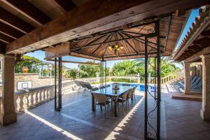 an open patio with a table and chairs and a pool at Villa Marina in Playa de Palma in Palma de Mallorca