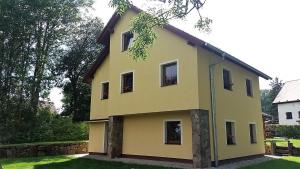 ein gelbes Haus mit Seitenfenstern in der Unterkunft Horní Planá in Horní Planá