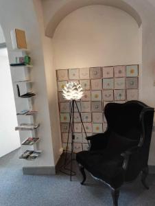 een kamer met een stoel, een lamp en een muur bij Hotel Du Square in Riom