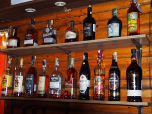 Kemp Prachovská osma في Libuň: مجموعة من زجاجات الكحول موجودة على الأرفف