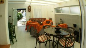 エンプリアブラバにあるEmpuries Cのテーブル、椅子、オレンジ色のバスローブが備わる客室です。