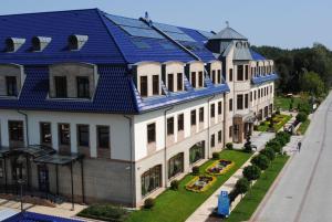 a large white building with a blue roof at Hotel Park Kajetany in Nadarzyn