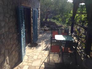 a patio with a table and chairs in front of a building at Lili Apartments, Sv Dunata 18 in Krk