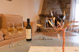 a bottle of wine sitting on a table with two wine glasses at Althaia in Áno Khóra