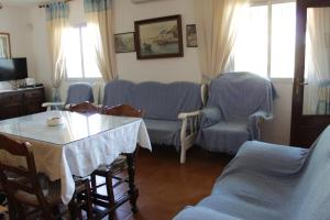 sala de estar con sofá, mesa y sillas en Casa Rural El Tejar, en Higuera de la Sierra