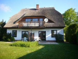 a large white house with a thatched roof at Ferienhaus Möwe in Lancken-Granitz