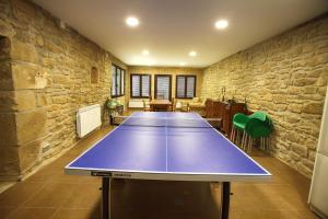 tavolo da ping pong in una stanza con muro in pietra di La Casona de Pitillas a Pitillas