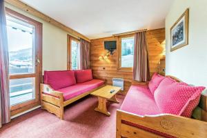 a living room with a red couch and a window at Les Résidences de Valmorel - maeva Home in Valmorel