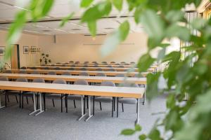 una sala de conferencias vacía con filas de mesas y sillas en Akademiehotel Jena, en Jena