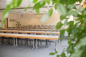 une salle de conférences vide avec rangées de tables et de chaises dans l'établissement Akademiehotel Jena, à Iéna