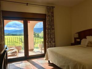 Brunyola的住宿－馬斯多克酒店，一间卧室设有一张床和一个美景阳台