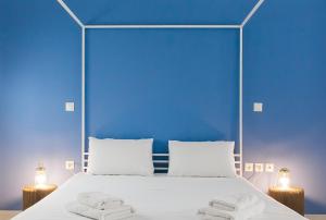 um quarto azul com uma cama com toalhas em Karitsi Place em Atenas