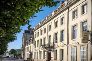 een groot wit gebouw aan de straatkant bij Hôtel Anne d'Anjou, The Originals Collection in Saumur