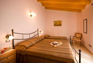 una camera da letto con un letto con un cappello sopra di Agriturismo Cascina Roveri a Monzambano