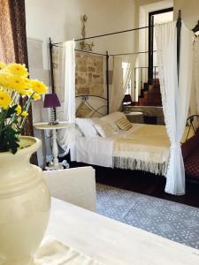 1 dormitorio con 1 cama y un jarrón con flores sobre una mesa en Marè Rooms Bari old town center, en Bari