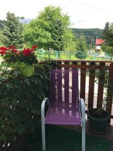 una sedia viola seduta su un balcone con fiori di Relaks a Szklarska Poręba