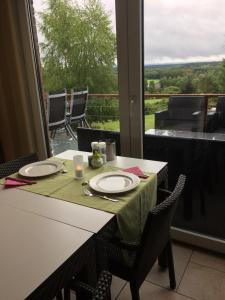 a table with two plates and a view from a window at B&B Villa Roma in Durbuy