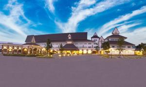un gran edificio con un estacionamiento delante de él en Major Grand Hotel, en Chum Phae