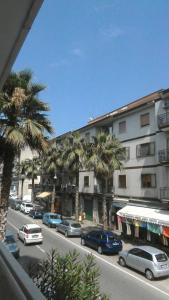a city street with cars and palm trees in front of a building at Camere In Centro in Agropoli
