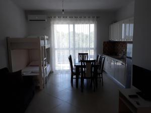 een keuken met een tafel en stoelen in een kamer bij Residence Kullat in Velipojë