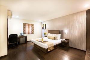 チェンナイにあるThe Lotus Apartment Hotel, Venkatraman Streetのベッドルーム1室(ベッド1台、デスク、コンピュータ付)