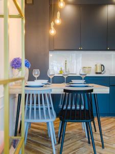 ウストロニエ・モルスキエにあるApartament DWIE SOSNYのキッチン(青いキャビネット、テーブル、椅子付)