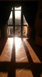 een kamer met een raam waar de zon doorheen schijnt bij Pensión Os Ancares in Becerreá