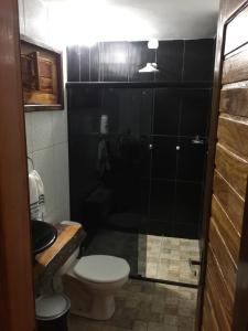a bathroom with a toilet and a glass shower at Villa Salgado in Barra Grande