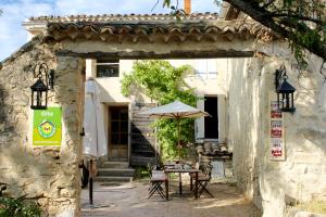 an outdoor table with an umbrella in a building at Mas de la Gonnette in Venasque
