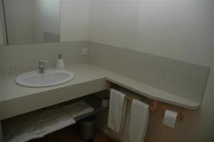 ein Badezimmer mit einem Waschbecken, einem Spiegel und Handtüchern in der Unterkunft La Fustana in Maia de Montcal