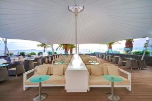 a restaurant with tables and chairs under a large umbrella at Hipotels Natura Palace Adults Only in Playa Blanca