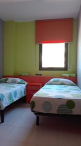 サロウにあるrosa sensatの緑の壁と窓が特徴の客室で、ベッド2台が備わります。