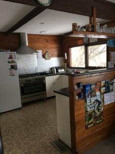 a kitchen with a stove and a refrigerator at Gliss Ski Club in Mount Buller